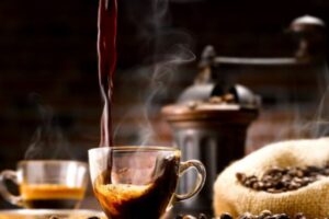 a cup of coffee being poured into a glass