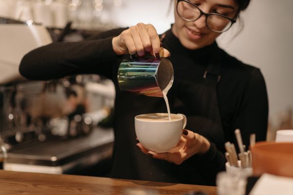 a woman pouring milk into a cup